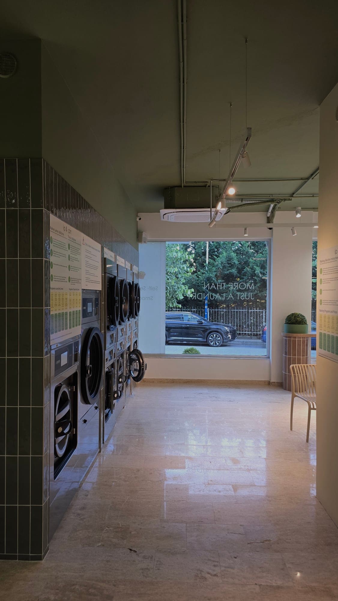 Domus washers and dryers along the wall of the Sip & Spin self-service laundry in Mali i Robit, Golem